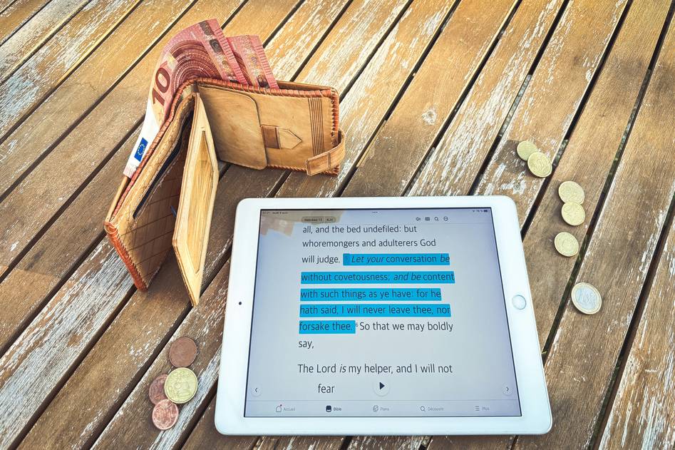 Person analyzing stock charts on a tablet with notepad and pen nearby
